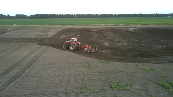 Cultivator Works in Field Plowing Fertile Soil Aerial View