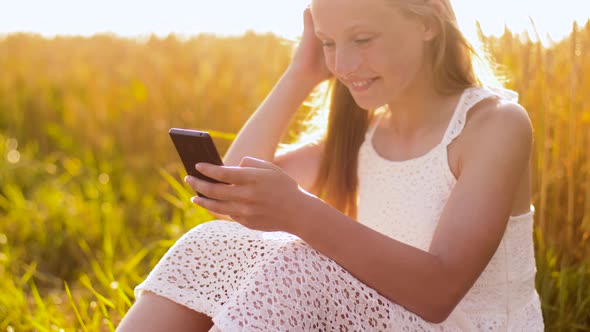 Happy Young Girl with Smartphone on Cereal Field