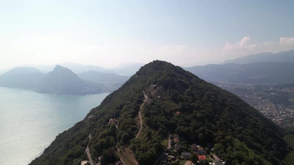 Aerial around monte bre with panorama look to town Lugano and lake Lugano.