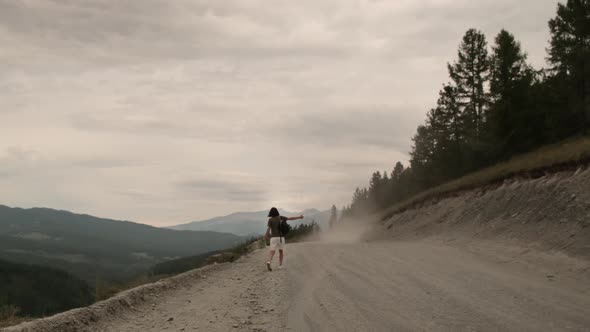 The girl is hitchhiking alone.