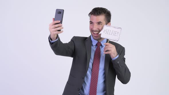 Young Happy Hispanic Businessman Taking Selfie with Paper Sign