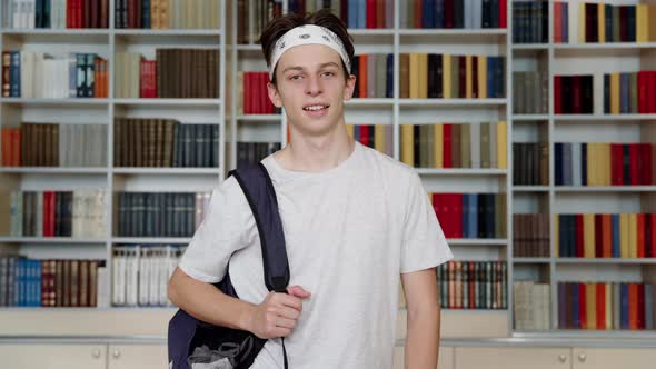 Single Portrait of Smiling Confident Male Student Teenager Looking at Camera in Library