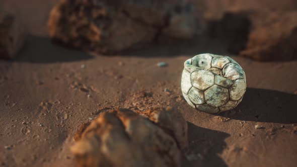 Old Football Ball on the Sand Beach