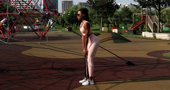 Fit black woman engaged in sports doing fitness training outdoors.