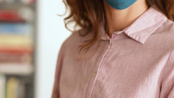 Caucasian woman wearing a face mask at home