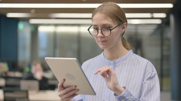 Portrait of Attractive Young Woman Using Tablet in Office