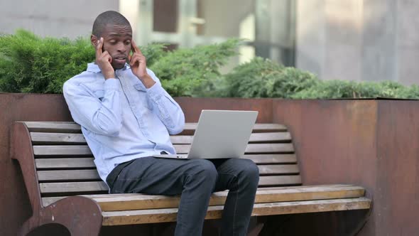 Young African Man with Laptop Having Headache Outdoor