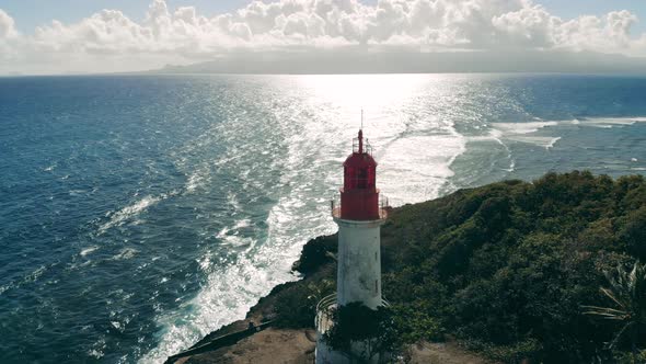 Sunlit Seashore with a White Lighthouse