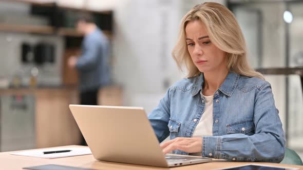 Young Woman with Laptop Showing Thumbs Down