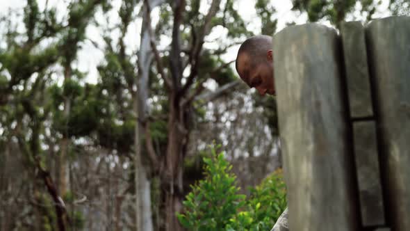 Military soldier climbing a wooden wall at boot camp 4k