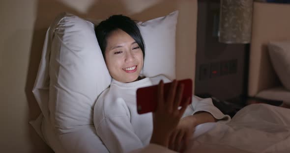 Woman watch on cellphone on bed