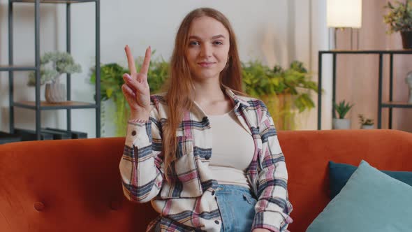 Young Woman Looking at Camera Showing Victory V Sign Hoping for Success Win Doing Peace Gesture