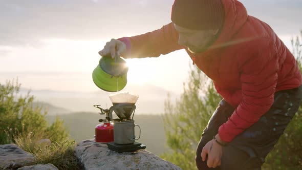 Man Traveller Makes Coffee in Camping Gear