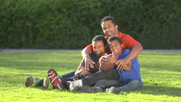 Group portrait of a father and his sons with a football.