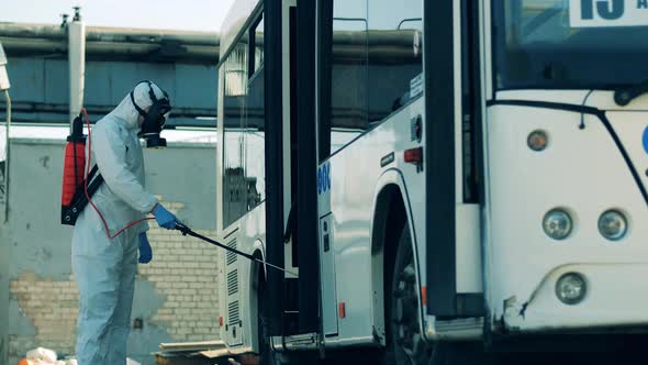 Disinfection of a Bus Exit Held By a Sanitation Worker