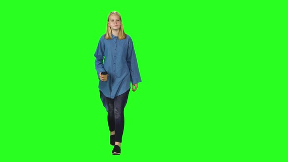 Blonde Teenager Girl Calmly Walking on Green Screen Background. Chroma Key,  Shot. Front View.