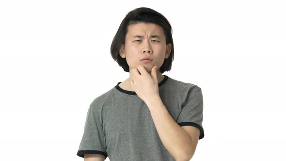 Portrait of Concentrated Chinese Man in Casual Gray Tshirt Touching His Chin and Thinking or