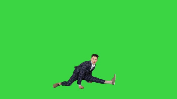 Young Attractive Male Dancer in the Strict Business Suit Dancing Making a Split on a Green Screen