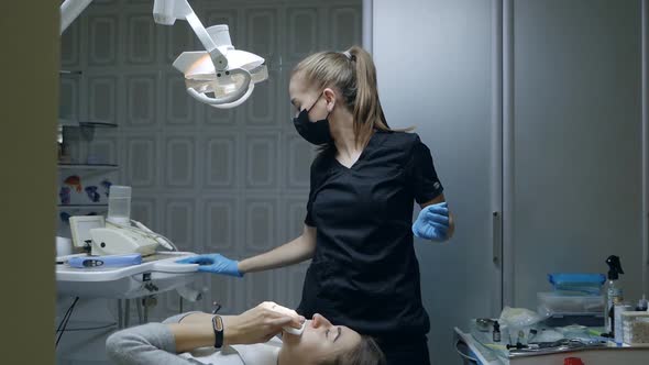 Young Woman Patient Getting Up From Chair After Dental Treatment in Dental Clinic Office