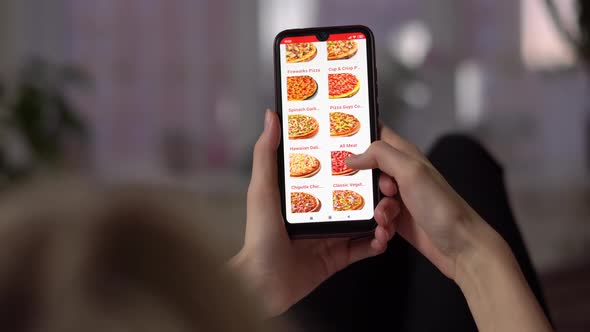 a Girl Uses a Phone with a Fast Food Pizza Delivery Website on the Screen