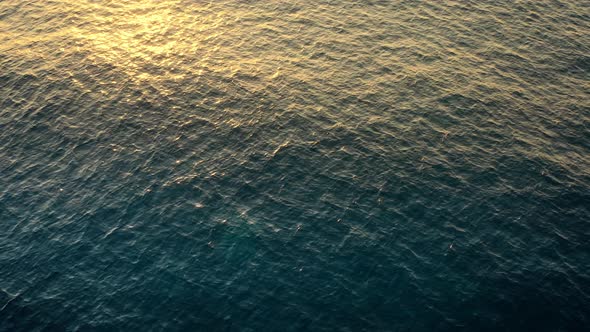 Sunlight reflected by an undulating and dark sea