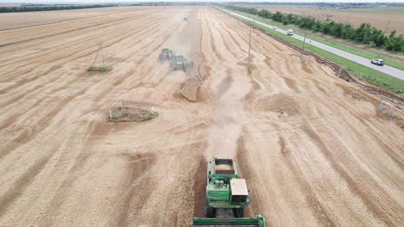 Aerial View of Harvester Machines Working in Wheat Field