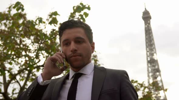 Businessman in a Black Suit Speaks on a Cell Phone