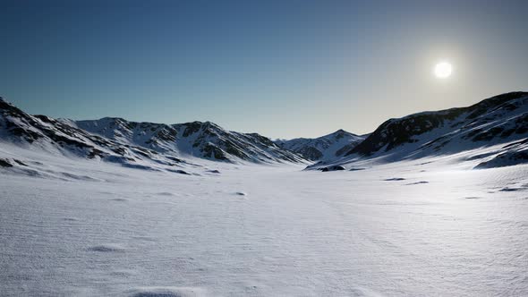 Aerial Landscape of Snowy Mountains and Icy Shores in Antarctica alt