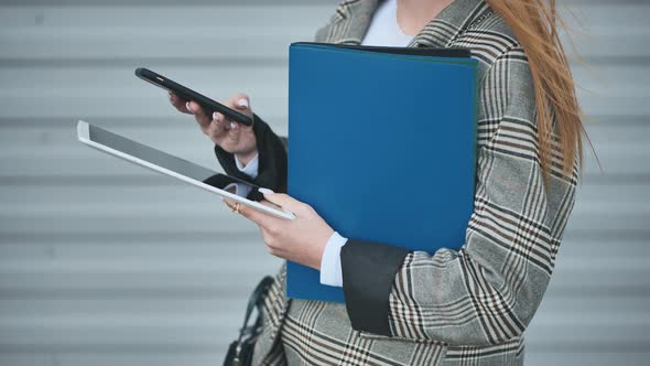Business Woman Works with a Tablet and a Phone
