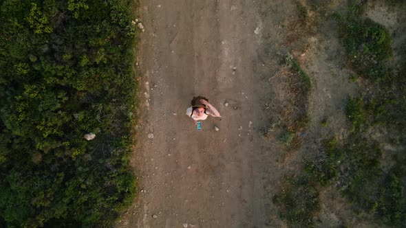 Attractive girl with smartphone launching drone up