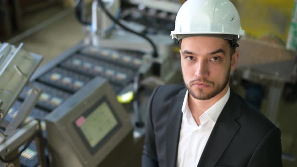 Portrait of a smiling successful plant manager in a white industrial helmet