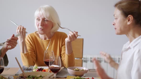 Serious mature women eating and talking