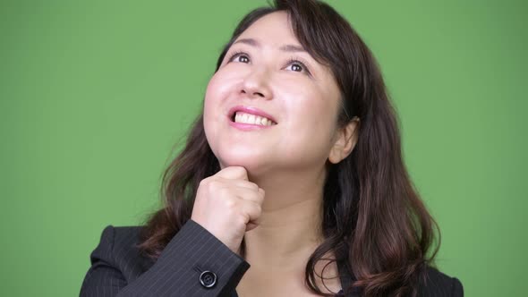 Mature Happy Beautiful Asian Businesswoman Smiling While Thinking