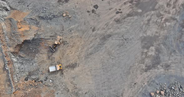 Aerial View in a Quarry Excavator and Dump Truck During the Loading of Mined Rock