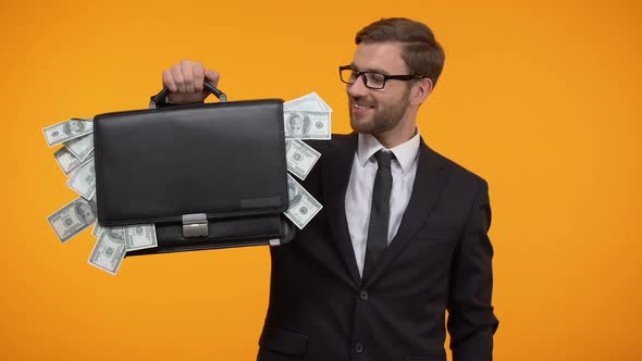 Man Showing Case Packed With Money, Winking and Doing Thumbs-Up, Loan, Credit