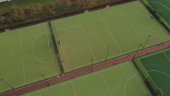 Aerial view that turns around a complex of multiple sport fields with artificial green grass