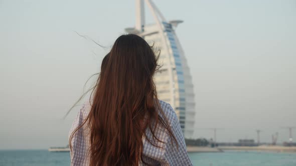 Woman Looking at Burj Al Arab Hotel in Dubai During Sunset