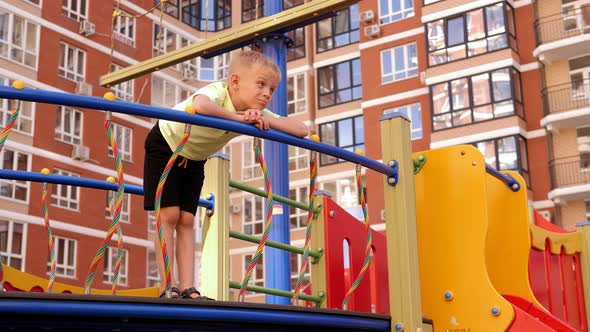 Portrait of a Sad Lonely Boy on the Playground of a Modern Residential Complex