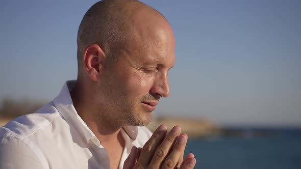 Closeup Religious Caucasian Man Praying in Sunshine on Picturesque Mediterranean Sea Beach in