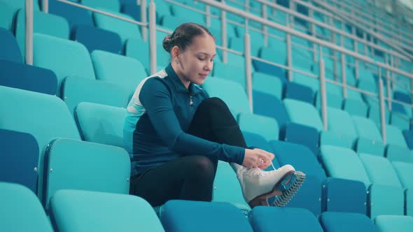 Young Lady is Getting Her Skates Ready for Practice