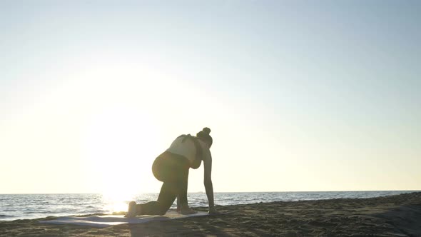 Young Caucasian Woman Practicing Yoga on the Beach Near Calm Sea.