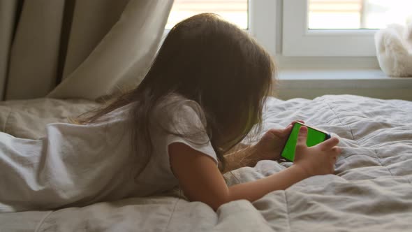 Little Girl Using Green Screen Smart Phone at Home