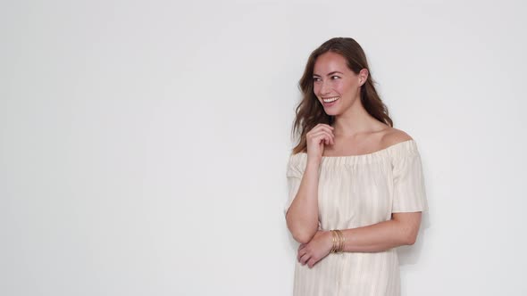 Model Laughing as the Wind Blows Her Hair Inside A Studio with White Background