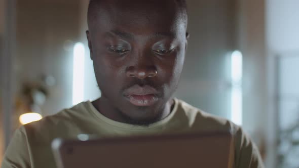 Man Working on Digital Tablet in Office at Night