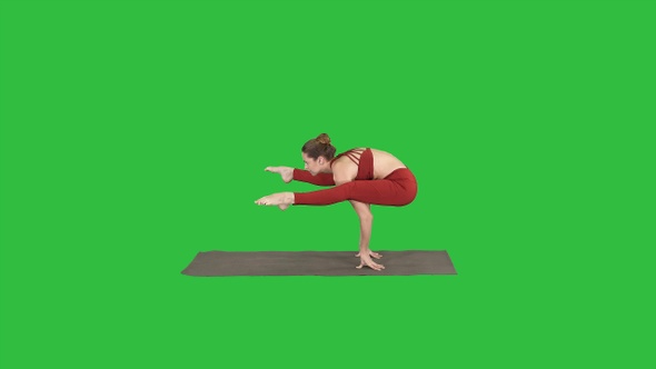 Beautiful woman practices handstand yoga asana Tittibhasana