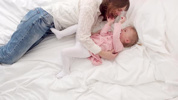 Top View Mother and Little Daughter Tickle Having Fun Jumping and Playing Funny Active Game in