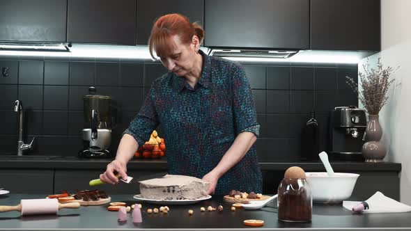 Pastry chef is cooking chocolate cream cake in home modern kitchen