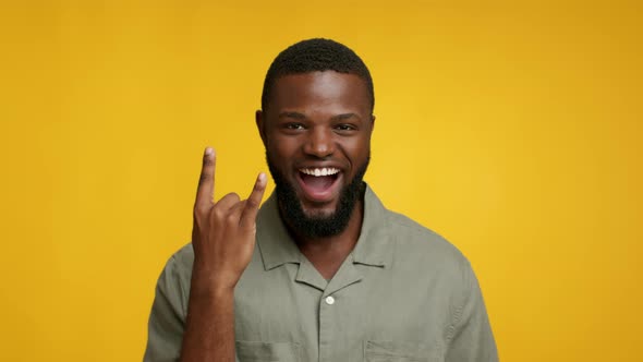 Cheerful Young Black Guy Showing Rock And Roll Gesture At Camera