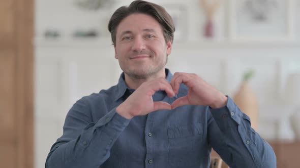 Portrait of Young Man showing Heart Shape by Hands