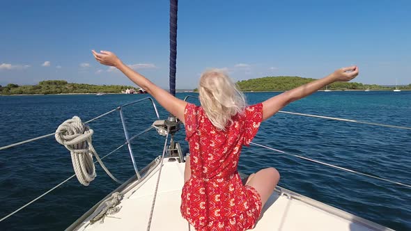 Woman Enjoing the Wind on Sailboat Bow